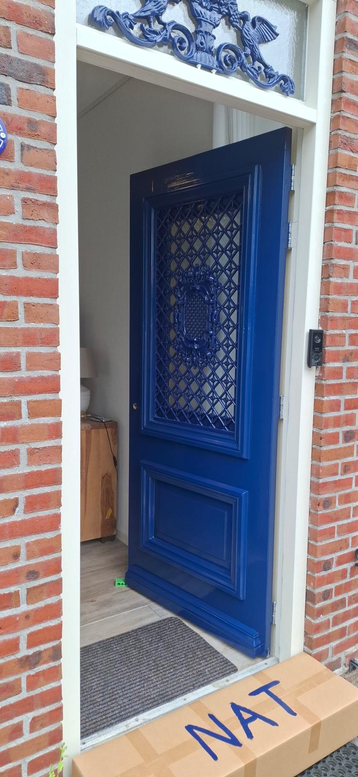 Hoogglans blauw gelakte voordeur met ornamenten — houtwerk schilderen in Groningen